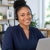 A smiling Goldie VA wearing a headset